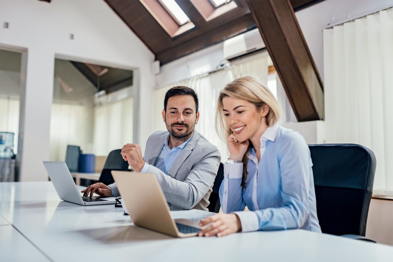 Administrateurs de biens : Comment développer son image de marque et attirer de nouveaux clients ? 2 personnes qui sont sur un bureau avec un ordinateur